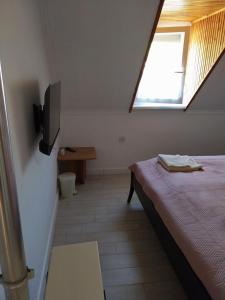 - une petite chambre avec un lit et une fenêtre dans l'établissement Pipacs Vendégház, à Bogács