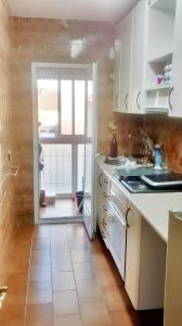 uma cozinha com armários brancos e uma porta para um pátio em 3 bedrooms apartement with furnished terrace and wifi at Navalcarnero 5 km away from the slopes em Navalcarnero