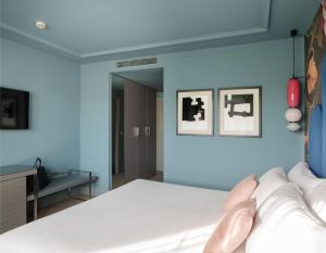 a blue bedroom with a bed and a mirror at Hotel Antik San Sebastián in Donostia-San Sebastián