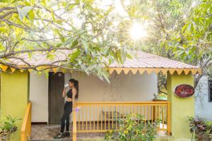 a woman standing on the porch of a house at Daksh Resort And Amusement Park in Sasan Gir