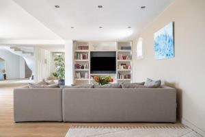 ein Wohnzimmer mit einem Sofa und einem TV in der Unterkunft Villa vue mer et pinède in Bandol