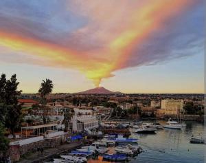 Blick auf einen Vulkan mit Booten im Hafen in der Unterkunft Le Finestre di Via Asiago in Catania
