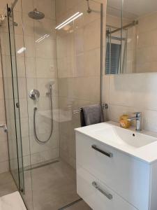 een badkamer met een douche en een witte wastafel bij APARTMAN SUNSIDE2 NIN in Nin
