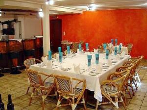 een lange witte tafel met stoelen en blauwe vazen erop bij Hotel zum Roten Löwen in Hildisrieden