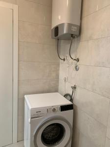 een wasmachine en droger in een badkamer met een wasmachine bij APARTMAN SUNSIDE2 NIN in Nin