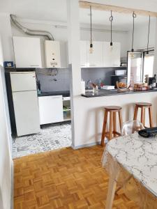 a kitchen with white cabinets and a table and chairs at One bedroom apartement with furnished balcony at Pombal in Pombal
