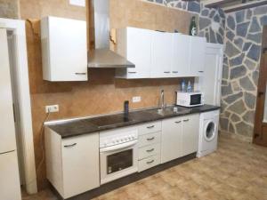 cocina con armarios blancos, fregadero y fogones en 4 bedrooms apartement with shared pool furnished terrace and wifi at Villarrobledo, en Villarrobledo