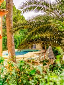 a view of a swimming pool with palm trees at LA VILLA MEDITERRANEA DE HERACLES en Denia in Denia