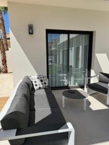 ein Wohnzimmer mit einer Couch und einem Sessel in der Unterkunft Villa Tortuga Blanca, Ciudad Quesada, Costa Blanca in Ciudad Quesada + 11 Fotos