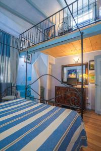 een slaapkamer met een blauw en wit bed en een wenteltrap bij Pozzo Antico in Morlupo