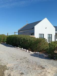 a white building with a road in front of it at Silver Oaks Airbnb in Langebaan