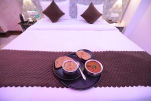 a tray with two bowls of food on a bed at Hotel Red Velvet suites in New Delhi