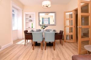 a dining room with a table and chairs and a mirror at Burnside in Tighnabruaich