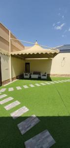 una casa con un patio verde con un edificio en استراحات توليب أبها, en Qāʼid