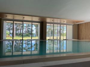 a swimming pool in a building with glass windows at My Marina Apartment mit Pool und Sauna am See in Bad Saarow