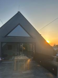 a house with a table and a sunset in the background at Designapartment Salzburg in Salzburg