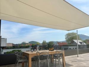 a table and chairs on a patio under a white umbrella at Designapartment Salzburg in Salzburg +16 photos