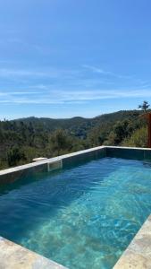 a large swimming pool with a view of the mountains at Herdade da Maceira in São Luis