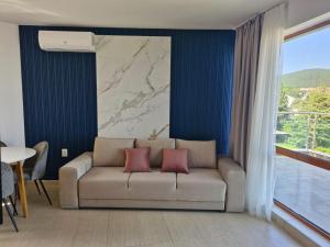 a living room with a couch with two pink pillows at APART SUNNY BAY a SUNNY BEACH in Sunny Beach