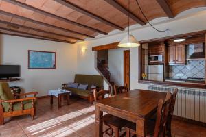 a living room with a table and a couch at Can Tubau - Casa rural - Apartaments in Campelles