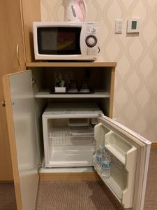 un forno a microonde seduto sopra un frigorifero di ホテル レディ a Kōtōdaitōri