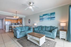 a living room with two blue couches and a table at Crystal Shores West 202 in Gulf Shores
