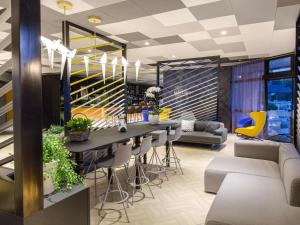 - un hall avec un bar avec des tabourets et des chaises dans l'établissement Mercure Hyères Centre Côte d'Azur, à Hyères