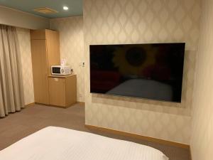 ホテル レディ في Kōtōdaitōri: غرفة بها تلفزيون كبير على الحائط