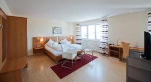 ein Wohnzimmer mit einem Sofa und einem Tisch in der Unterkunft Hotel Am Froschbächel in Bühl