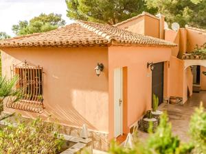 a small peach colored house with a gate at LA VILLA MEDITERRANEA DE HERACLES en Denia in Denia +19 photos