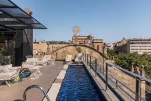 a pool on the roof of a building with a bridge at Hotel Bagués, a Small Luxury Hotel of the World in Barcelona