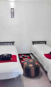dos camas sentadas una al lado de la otra en una habitación en 2 bedrooms apartement with city view and garden at Fes, en Fez
