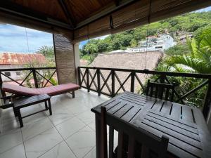 porche con banco y mesa en el balcón en Résidence Kambana, en Nosy Be