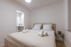 Un dormitorio con una cama blanca con toallas. en Comfortable apartment near the sea en Knokke-Heist