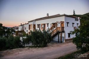 a large white house on a dirt road at Casa Rural TorreMontero Apartamentos in Hornos el Viejo