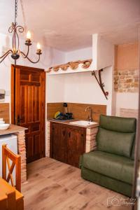 a kitchen with a green chair and a sink at Casa Rural TorreMontero Apartamentos in Hornos el Viejo
