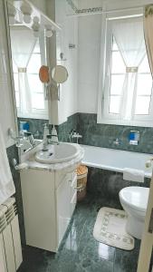 ein Badezimmer mit einem Waschbecken, einem WC und einem Spiegel in der Unterkunft 3 bedrooms apartement at A Coruna 200 m away from the beach with wifi in A Coruña