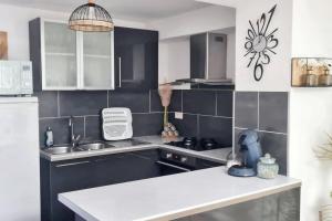 eine Küche mit schwarzen und weißen Fliesen und einem Waschbecken in der Unterkunft Appartement de 2 chambres avec wifi a Raismes in Raismes