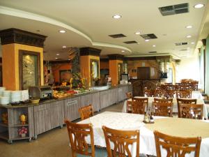 a restaurant with tables and chairs and a buffet at Hotel Kamenec in Kiten