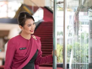 a woman in a purple sweater looking at a window at Pullman Jakarta Indonesia in Jakarta