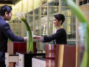 a man and a woman holding a vase of flowers at Pullman Jakarta Indonesia in Jakarta