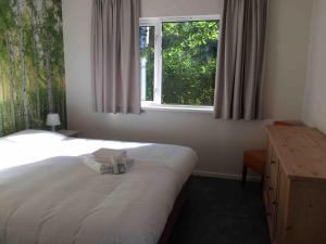 1 dormitorio con 1 cama, ventana y toallas en Landgoed Leudal, en Haelen