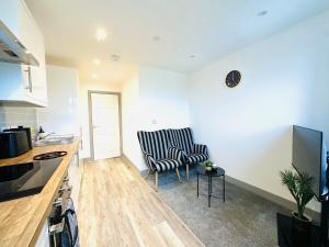 a living room with a chair and a table at 301 Grosvenor House in Wakefield +18 photos