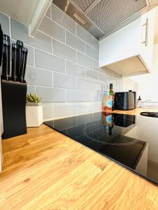 a kitchen with a black counter top and white appliances at 301 Grosvenor House in Wakefield