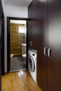 a bathroom with a washing machine and a toilet at Apartament Family Rivulus 9 in Baia Mare