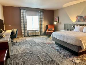 a hotel room with a bed and a chair at Hilton Garden Inn Oconomowoc in Oconomowoc +42 photos