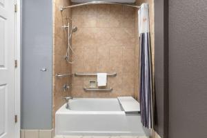 a bathroom with a white tub and a shower at La Quinta by Wyndham Belton - Temple South in Belton