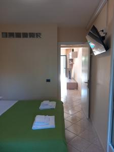 sypialnia z zielonym łóżkiem i łazienką w obiekcie Casa Mare Ludovica w mieście Vasto