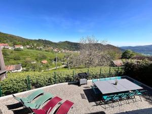 a patio with chairs and a table and a grill at La Fermette des Vallons - Col du Haag in Geishouse