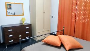 um quarto com uma cama com uma cortina laranja e uma cómoda em 2 bedrooms apartement with city view at Avola 1 km away from the beach em Avola